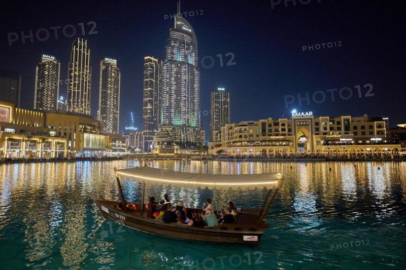 Dubai, United Arab Emirates, AsiaTourists ride in a boat in front of the skyscraper backdrop at Lake Burj Khalifa, Asia