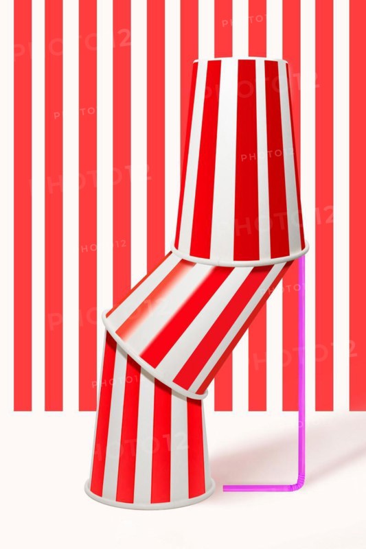 Three red striped drinking cups stacked inside each other with straw