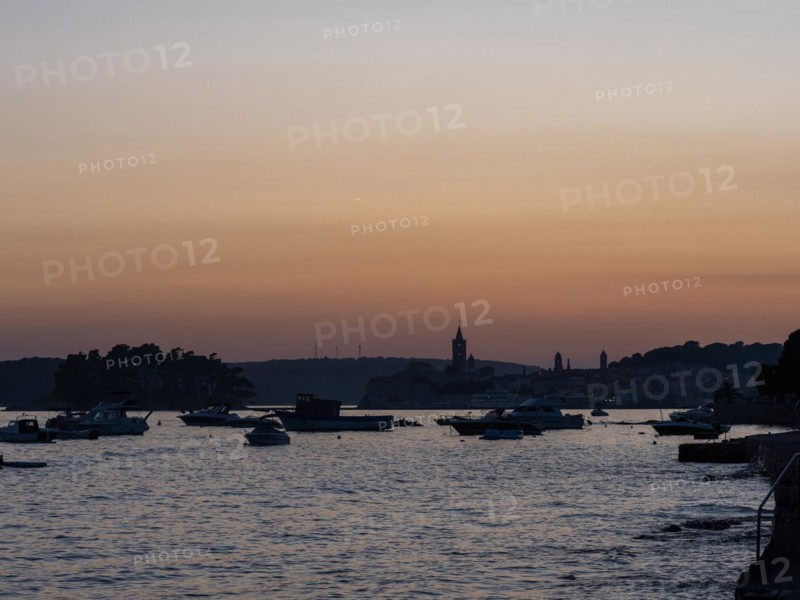 Boats anchoring in a bay, church towers, evening mood after sunset over Rab, town of Rab, island of Rab, Kvarner Gulf Bay, Croatia, Europe