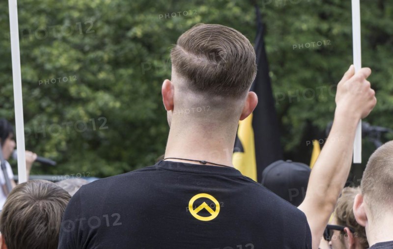 A member of the Identitarian Movement stands among the demonstrators with the Identitarian Movement logo on his shirt. Several hundred supporters of the Identitarian Movement demonstrated in Berlin under the slogan Future Europe - for the defence of our identity, culture and way of life . The right-wing group is being monitored by the Office for the Protection of the Constitution, 17.06.2017