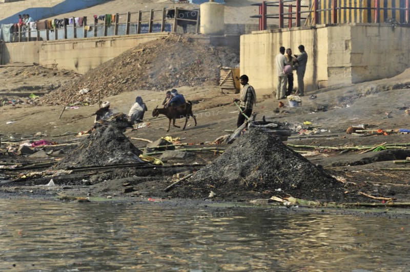 Busy riverbank full of people and animals, smoke and pollution emphasise the daily drama, Varanasi, Uttar Pradesh, India, Asia