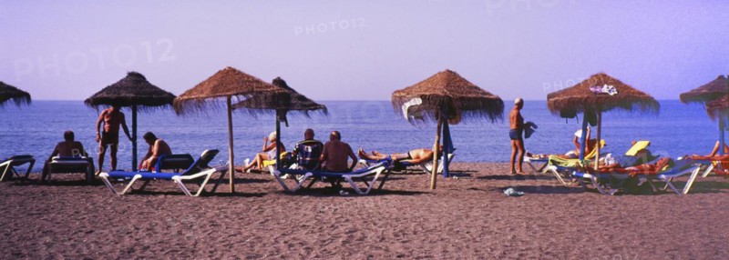 Sunbathers with parasols on the beach in Torre del Mar, Costa del Sol, Malaga province, Andalusia, Spain, Southern Europe. Scanned slide, Europe