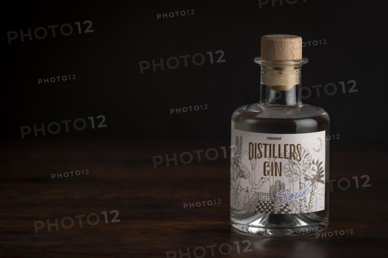 Bottle of gin on a dark wooden table with soft lighting