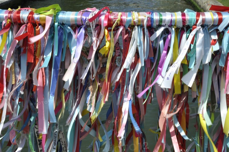 Vibrant colorful ribbons tied to a bridge's railing over water, representing a festive or cultural tradition, Aveiro, canal, portugal, tour tourism, bridge, outdoors, river, aveiro, colourful, no people, sightseeing, color image, famous place, multi colored, aveiro city, aveiro district, bridge, built structure, ribbon, sewing item
