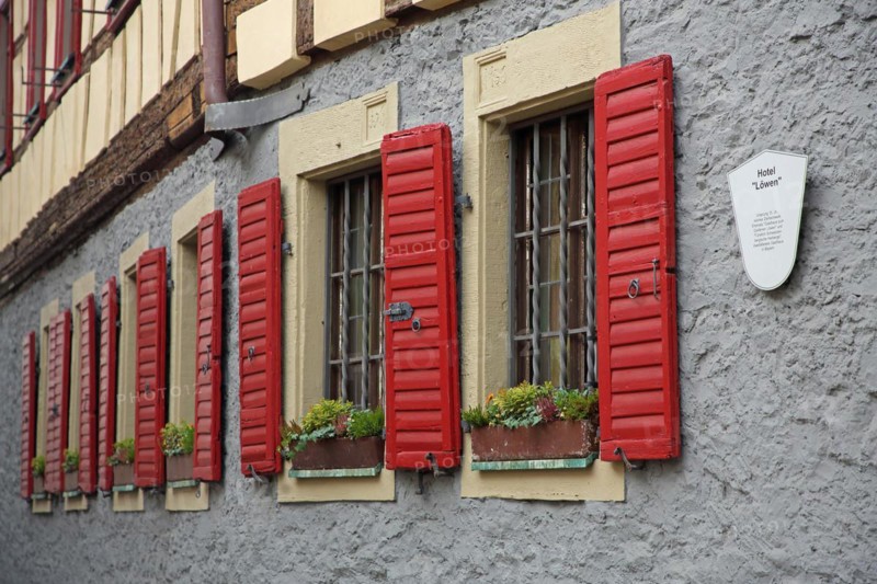 Row of red shutters on the Hotel Loewen, bars, bars, metal bars, shutter, house wall, red, window, detail, Marktbreit, Lower Franconia, Franconia, Bavaria, Germany, Europe