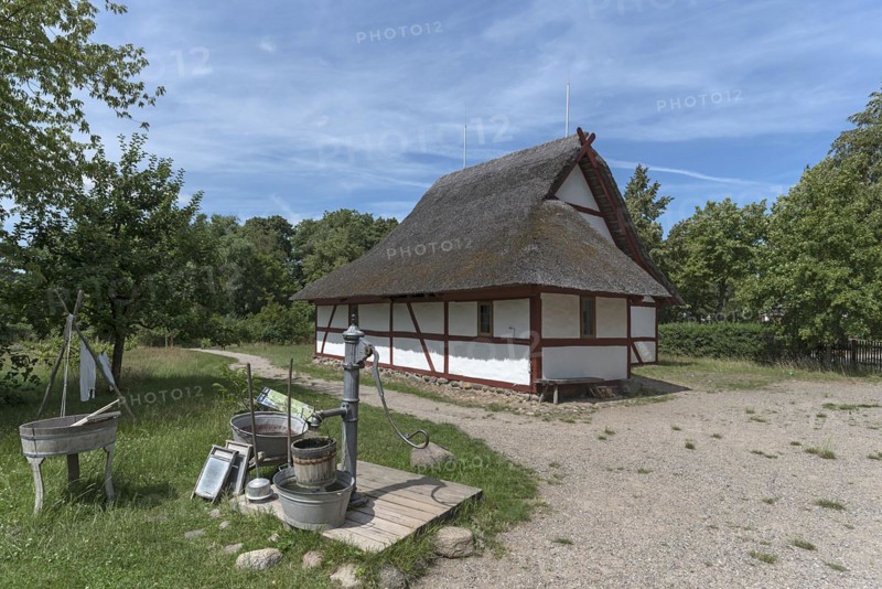 Thatched half-timbered barn, in front a water pump with washing tubs from the 19th century, open-air museum for folklore Schwerin-Muess, Mecklenburg-Vorpommerm, Germany, Europe