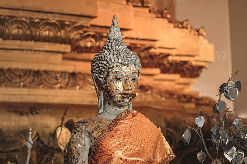 Gilded Buddha statue with worn texture wrapped in orange fabric. Ayutthaya, Thailand, Asia