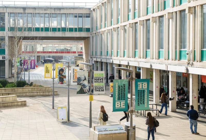 Students walking in campus square area, University of Essex, Colchester, Essex, England, UK