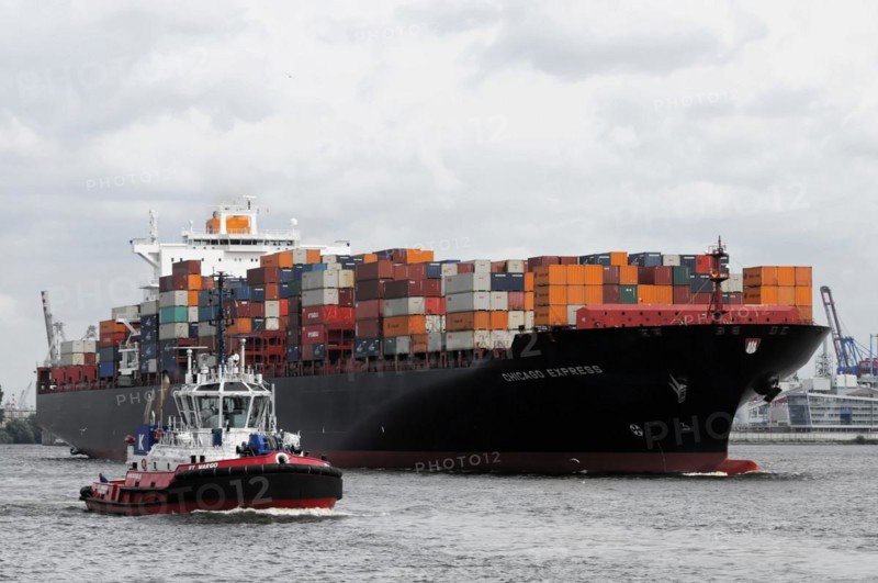 A large container ship loaded with colourful containers escorted by a tugboat, Hamburg, Hanseatic City of Hamburg, Germany, Europe