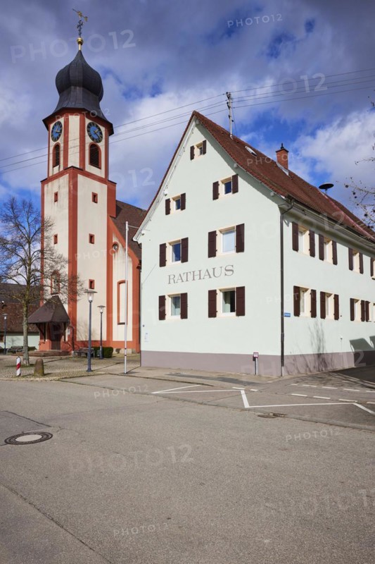 St John's Church and town hall under a blue sky with white cumulus clouds in Bad Krozingen, Breisgau-Hochschwarzwald district, Baden-Wuerttemberg, Germany, Europe