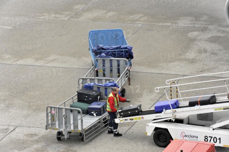 Ground staff loading luggage onto the conveyor belt of an aircraft, Hamburg, Hanseatic City of Hamburg, Germany, Europe