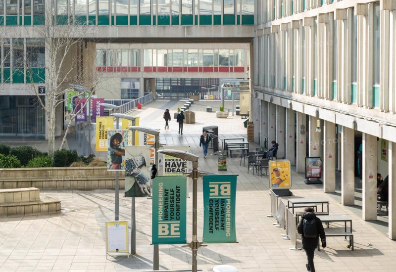 Students walking in campus square area, University of Essex, Colchester, Essex, England, UK