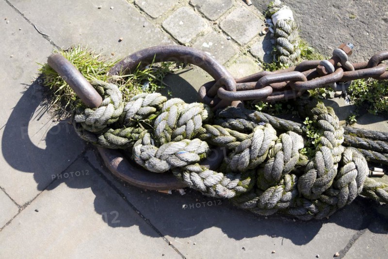 Old rusty iron ship mooring ring and ropes on a quayside at Ipswich Wet Dock, England, UK