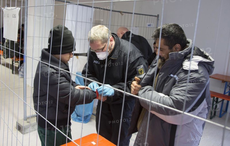 Refugees are searched by federal police officers after their arrival at Rosenheim station, 05/02/2016