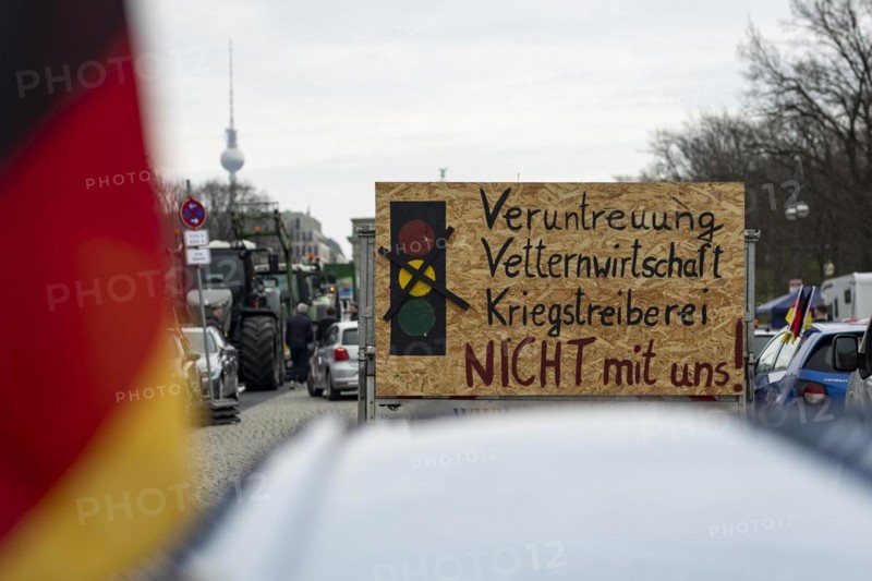 A demonstration sign mounted on a car trailer, vehicles blocking Strasse des 17. Juni, the Berlin TV tower in the background, taken as part of the 'AeoeFarmers' protests'Aeo in Berlin, 22/03/2024