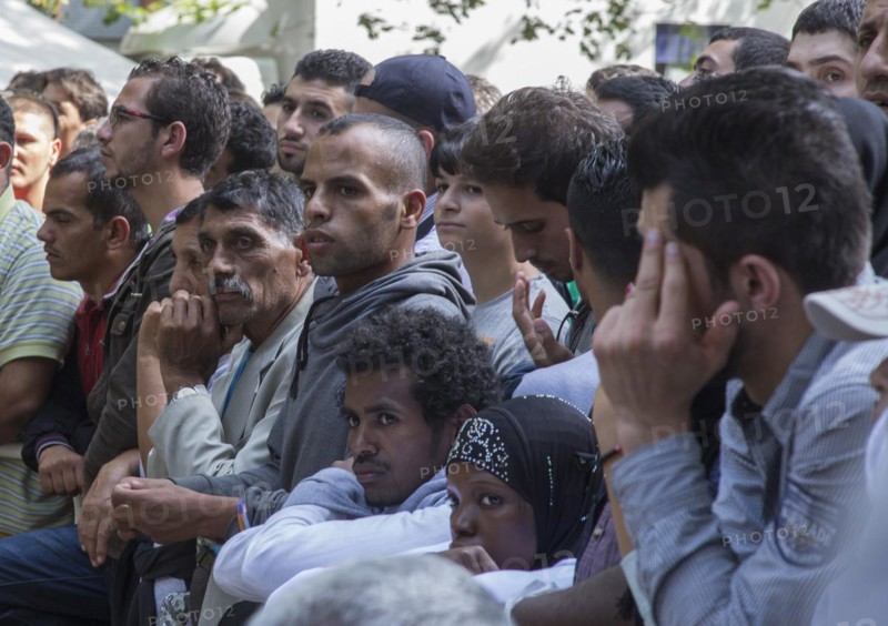 Refugees from Syria wait behind barriers in the central reception centre for asylum seekers at the State Office for Health and Social Affairs in Berlin, 26/08/2015