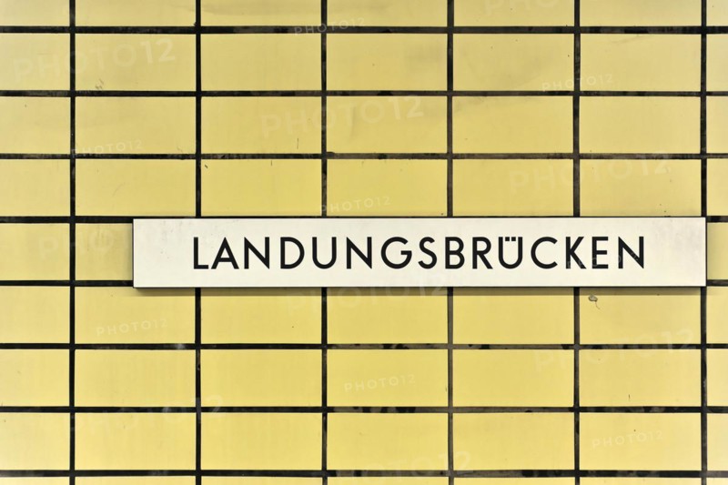 A sign with the inscription 'Landungsbruecken' on a yellow tiled wall, Hamburg, Hanseatic City of Hamburg, Germany, Europe