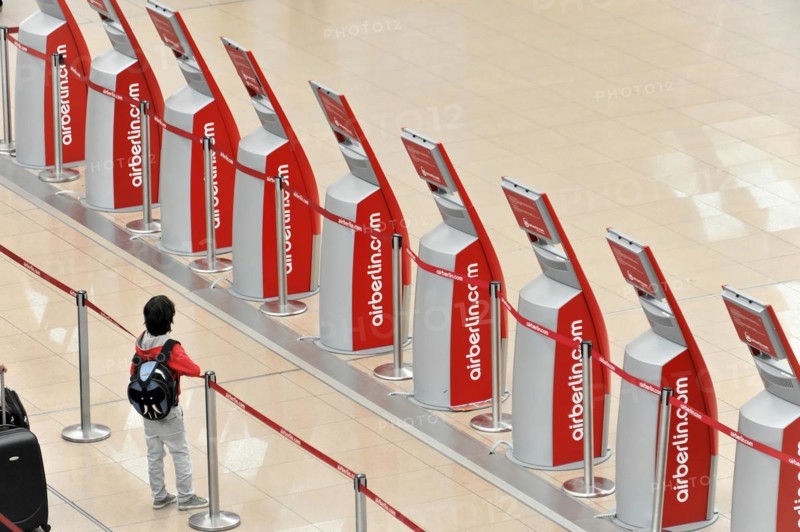 A child standing in front of self-service check-in machines in an airport queue, Hamburg, Hanseatic City of Hamburg, Germany, Europe