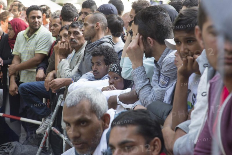 Refugees from Syria wait behind barriers in the central reception centre for asylum seekers at the State Office for Health and Social Affairs in Berlin, 26/08/2015