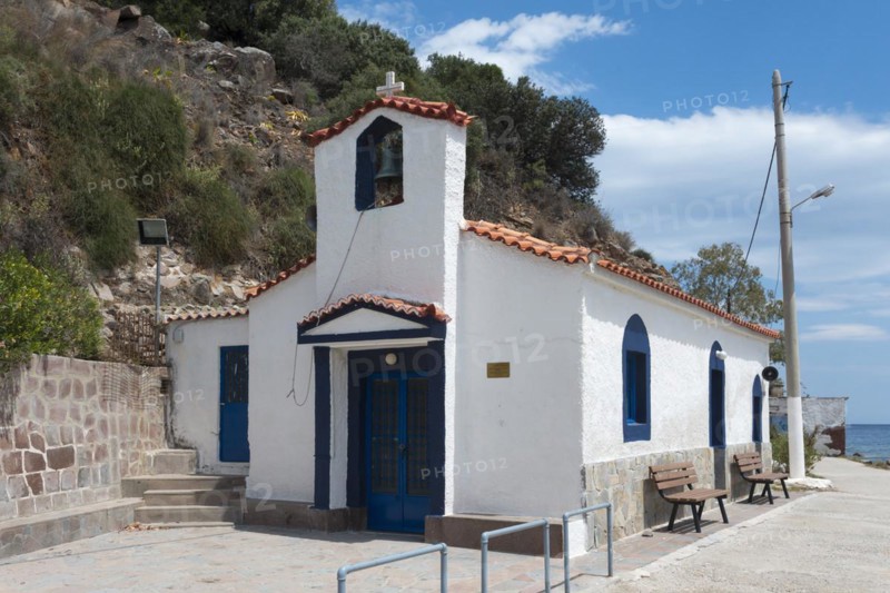 Small white chapel with blue accents located next to a quiet street, Holy Cross Church, Poros, Poros Island, Saronic Islands, Peloponnese, Greece, Europe