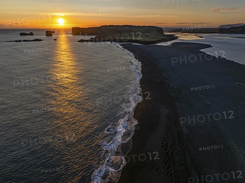Sunset over the rocks of Dyrholaey, drone shot, Sudurland, Iceland, Europe