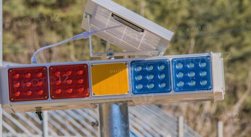 Traffic lights with LED panels in red, amber, and blue mounted on a pole, in South Korea