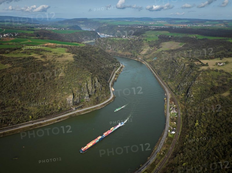 A container ship passes the Middle Rhine near Oberwesel, Rhineland-Palatinate, Germany, Europe