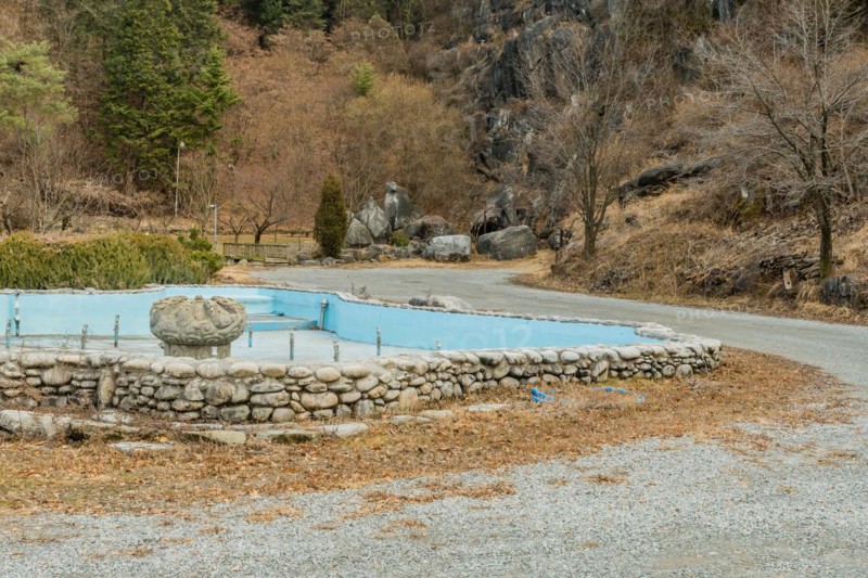 Empty water fountain with large concrete ornamental center piece in mountainside public park in Daejeon, South Korea, Asia