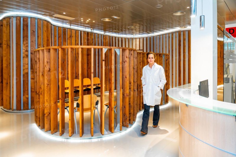 Ophthalmologist walking along a corridor to reception in a clinic with no people around