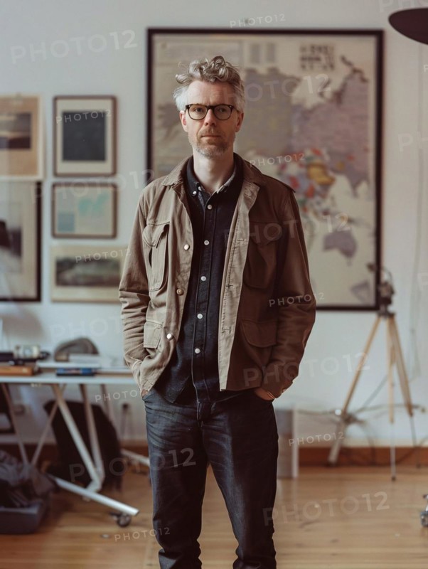 A casually dressed man with glasses standing confidently in his creative workspace, AI generated