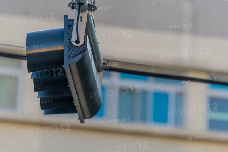 Bottom view of traffic light hanging from metal support with building blurred in background in Daejeon, South Korea, Asia