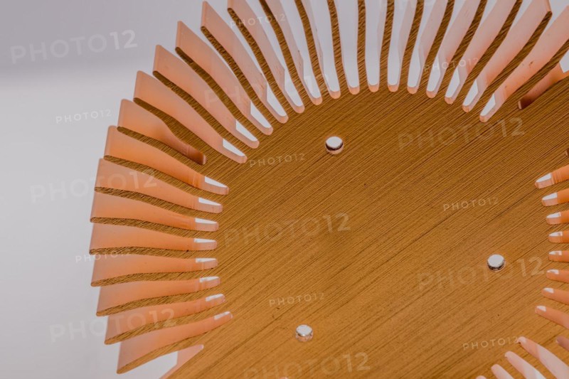 Closeup of mounting surface of round copper heat sink on white background