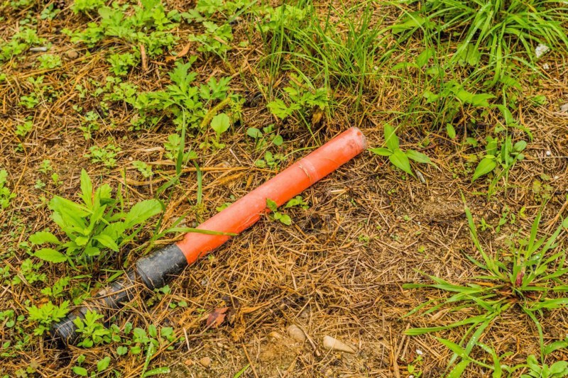 An orange tube on the grassy ground, symbolizing the issue of littering in natural areas, in South Korea