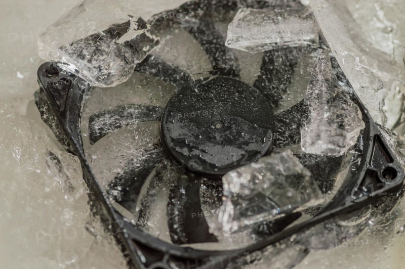 Closeup of computer case fan frozen in block of ice. Concept keep your computer cool