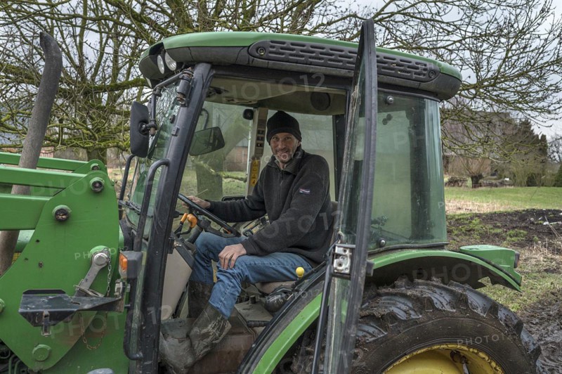 Young farmer in the tractor cab on his farm, Othenstorf, Mecklenburg-Vorpommern, Germany, Europe