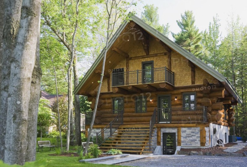 Luxurious two story Scandinavian style log cabin home facade in late spring, Quebec, Canada, North America