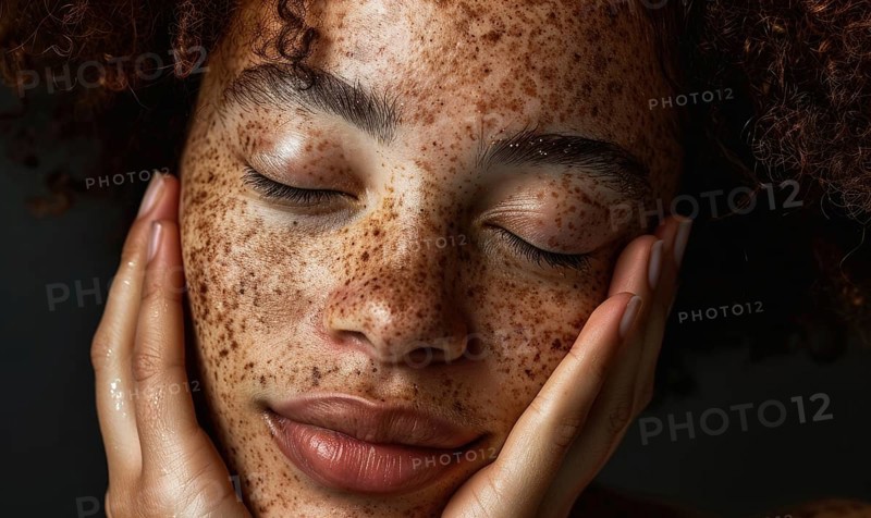 Close-up of a serene woman with freckles, eyes closed, hands on her cheeks AI generated