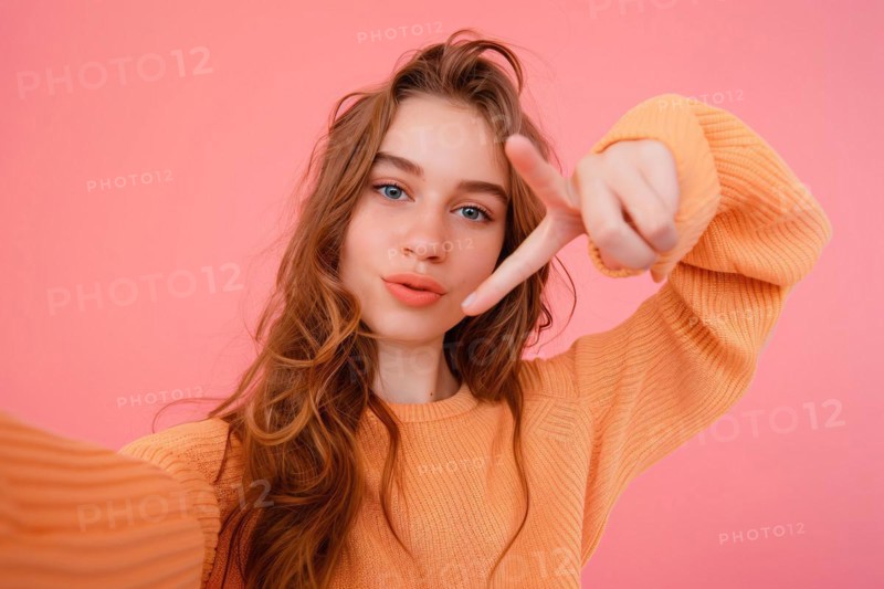 Young teenage girl taking selfie in front of pink studio background. KI generiert, generiert, AI generated