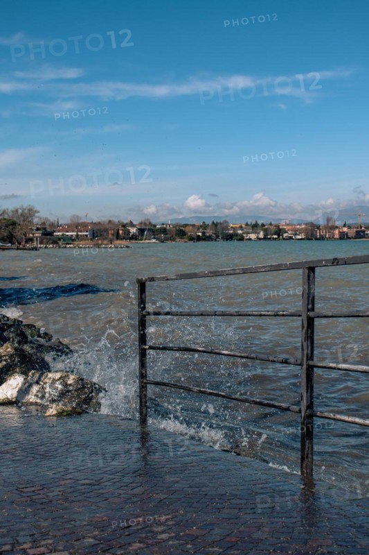 Splashing waves hitting rocks on the shore of Lake Garda, Sirmione, Lake Garda, Italy, Europe