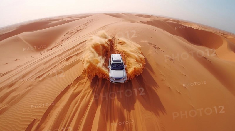 A solitary vehicle leaves a trail of dust in its wake as it traverses towering sand dunes, action sports drone aerial photography, AI generated