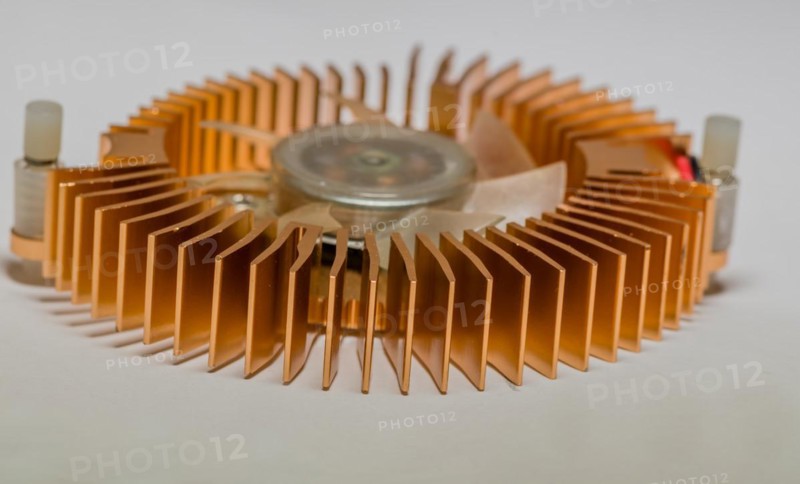 Closeup of round copper heat sink and plastic fan assembly on white background