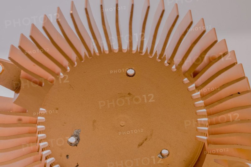 Closeup of copper heat sink fins and fan mounting surface with chipped screw holes