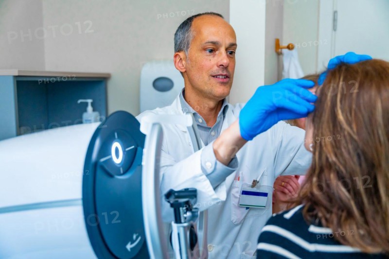 Ophthalmologist and mature woman during treatment for glaucoma using laser machine in a clinic