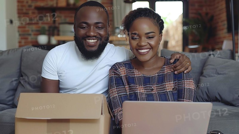 A smiling Mixed-race dark skinned couple unpacking boxes at home with a laptop on the table, showcasing partnership, AI generated