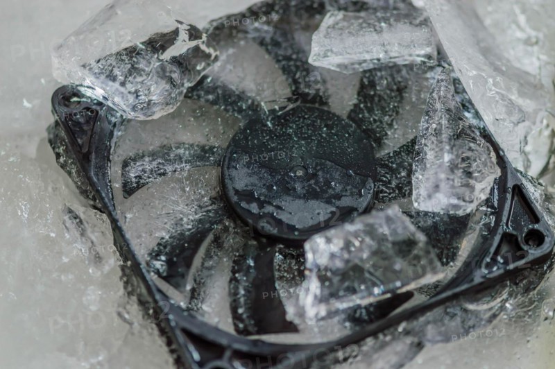 Closeup of computer case fan frozen in block of ice. Concept keep your computer cool