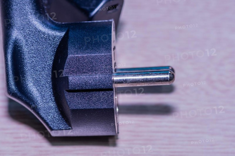Closeup of computer power cord plug that plugs into electrical socket