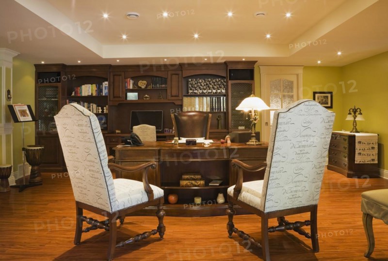 Wooden desk, high back chairs and wall unit in basement home office inside elegant style home, Quebec, Canada, North America