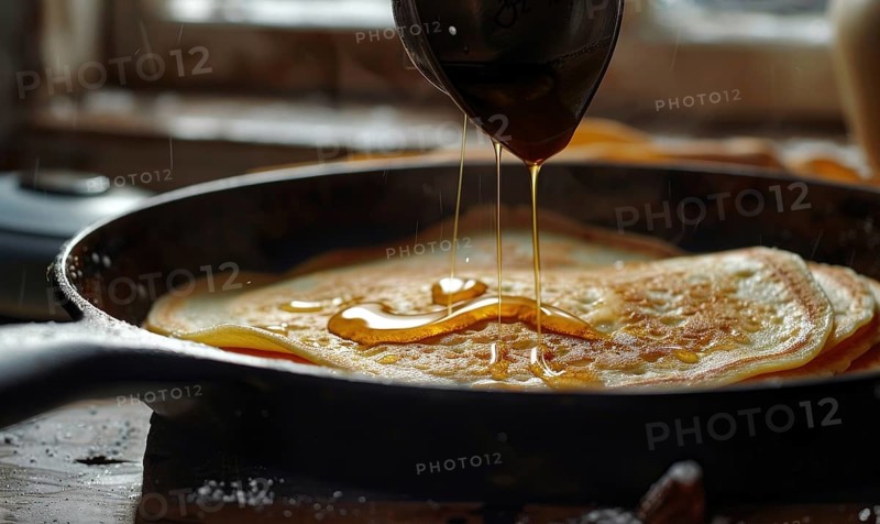 Golden brown pancakes in a cast iron pan being drizzled with sticky syrup AI generated