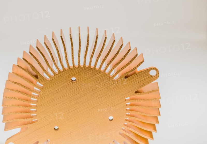 Closeup of mounting surface of round copper heat sink on white background