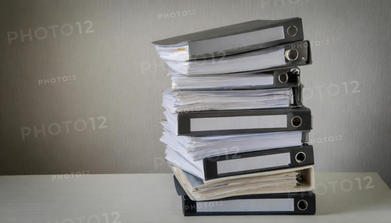 A high pile of files on a table symbolises a large workload, symbolism bureaucracy, AI generated, AI generated
